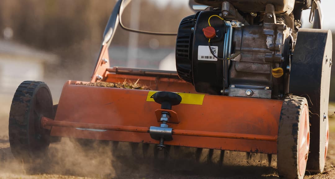 a person pushing a lawn aeration machine